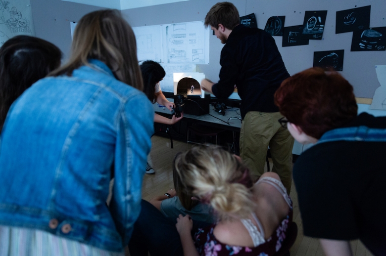 Students watching a light demonstration into a set model.